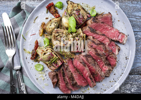 Grill Point Steak mit Artischockenherzen auf Platte Stockfoto