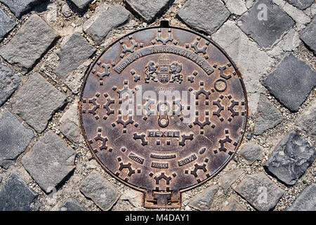 BUDAPEST, Ungarn - April 1, 2017: Ein Bügeleisen Kanaldeckel in einer Straße mit Kopfsteinpflaster verfügt über eine dekorative Muster. Stockfoto