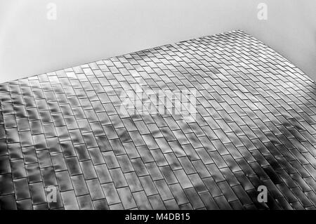 Moderne Architektur abstrakt einen Abschnitt einer Wand aus vielen Metallpaneele Licht, erstreckt sich in Richtung Himmel widerspiegelt. Stockfoto