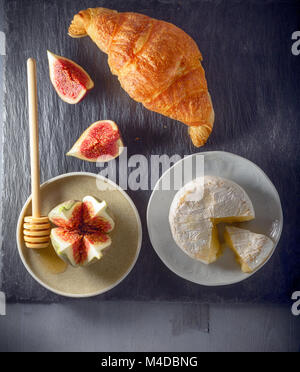 Croissant mit Käse und Feigen auf einer Steinplatte Stockfoto