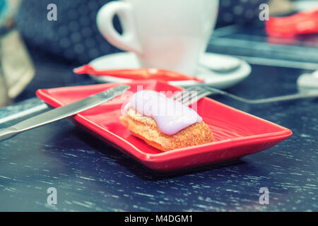 Eclair Kuchen in eine Rote rechteckige Platte Stockfoto