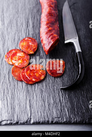 Spanische Chorizo mit einem Messer auf eine Steinplatte. Stockfoto