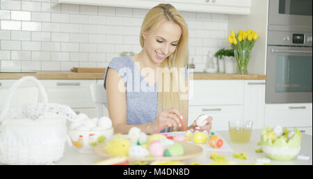 Fröhliche Frau Malerei Ostereier Stockfoto