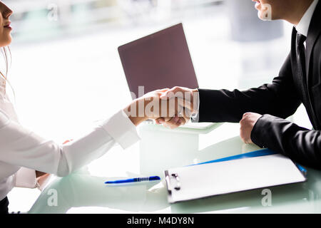 Nahaufnahme der Geschäftsleute Händeschütteln an Schreibtisch Stockfoto