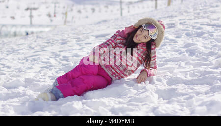 Junge Frau in rosa Schneeanzug mit skibrille Stockfoto