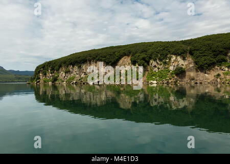 Schöne Küste der Kurilen See spiegelt sich im Wasser. Stockfoto