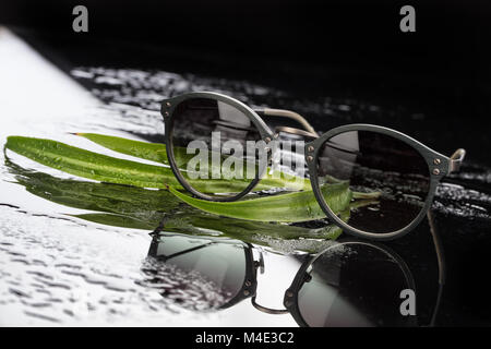 Sonnenbrille auf Glas Stockfoto