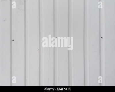 Die Entwicklung des abstrakten Hintergrund von einem hellen grau Metall oberfläche mit vertikalen Streifen, in der Mitte einige dunkle Punkte der Hüte von Schrauben. Stockfoto