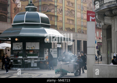 Lissabon, Portugal: Verkauf von gerösteten Kastanien in der Nähe der U-Bahn-Station Saldanha, Getränkestand und Gebäude im Stadtzentrum, Straßenszene. Stockfoto