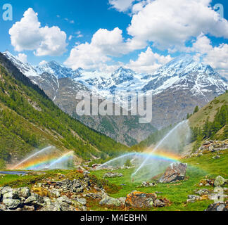 Regenbögen in Wasser zur Bewässerung im Sommer Alpen Berg Tüllen Stockfoto