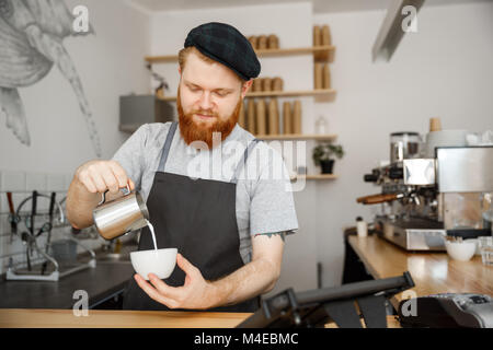 Kaffee Business Konzept - gut aussehender bärtiger Mann im Vorfeld Kaffee im Stehen im Cafe Stockfoto