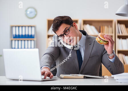 Hungrige lustige Geschäftsmann Essen Junk-Food-sandwich Stockfoto