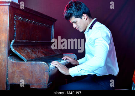 Mann spielt alte Vintage Piano, Pune, Maharashtra. Stockfoto