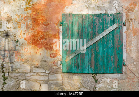 Alte geschlossen türkis Holz- Fenster auf einem zerstörten Gebäudewand Stockfoto