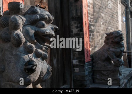 Ein Paar Steinlöwen Statuen bewacht den Eingang zu einem Haus in dem Dorf in der Nähe von dangjiacun Hancheng, Provinz Shaanxi, China. Stockfoto