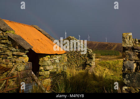 Alte landwirtschaftliche Gebäude übersehen durch Lenanavea Windpark Castlebar - und einen Regenbogen, County Mayo Irland Stockfoto