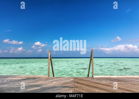 Holzsteg in Richtung Wasser Villen auf den Malediven. Stockfoto