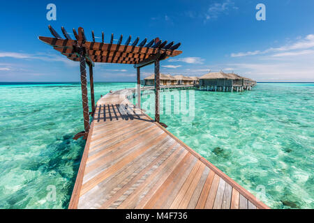 Holzsteg in Richtung Wasser Villen auf den Malediven. Stockfoto