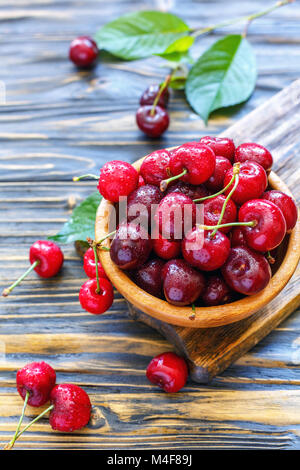 Rote Kirschen in eine hölzerne Schüssel. Stockfoto