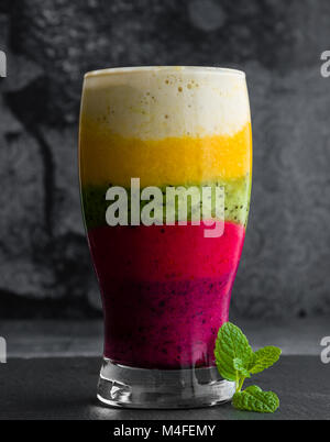 Bunte Smoothie aus verschiedenen Früchten schichtweise in ein Glas Stockfoto