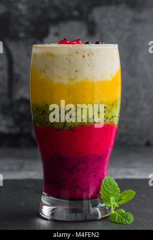 Bunte Smoothie aus verschiedenen Früchten schichtweise in ein Glas Stockfoto