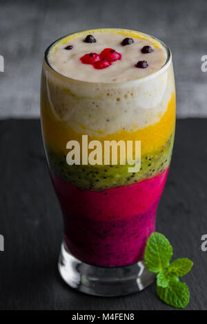Bunte Smoothie aus verschiedenen Früchten schichtweise in ein Glas Stockfoto