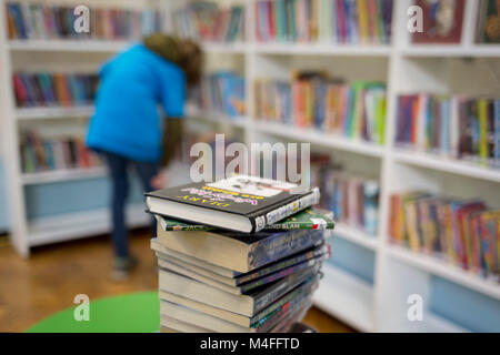 Ein junger Leser sammelt Bücher zum Ausleihen in der neu-eröffneten Carnegie Library auf Herne Hill im Süden Londons, die seine Türen zum ersten Mal in fast 2 Jahren geöffnet hat, die am 15. Februar 2018 in London, England. Von Lambeth Rat geschlossen und belegt durch Demonstranten für 10 Tage im Jahr 2016, wird die Bibliothek vermacht von uns Philanthrop Andrew Carnegie hat überhaupt gesperrt, weil, sagen Lambeth Sparmaßnahmen notwendig sind. Eine Turnhalle, die Einheimischen sagen, dass Sie nicht wollen oder müssen, hat im Keller und Bibliothek Raum einen Bruchteil wie vor und es ist keine qualifizierte Bibliothekare geglaubt installiert Stockfoto