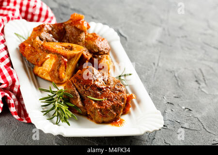 Geschmorten italienischen Rindfleisch am Knochen mit Rosmarin und Tomatensauce gekocht Stockfoto