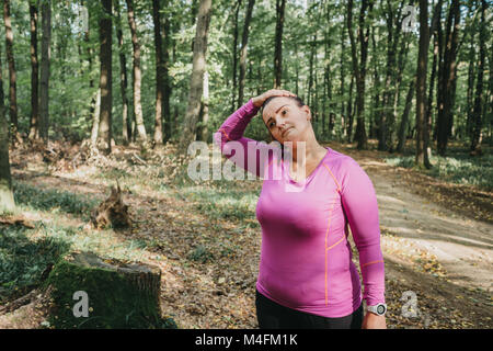 Porträt einer kurvenreichen weibliche Jogger Aufwärmen vor einem morgens joggen. Stockfoto