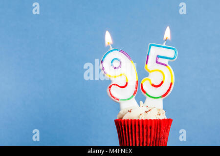 Nummer 95 geburtstag Kerze in eine Cupcake vor einem blauen Hintergrund Stockfoto