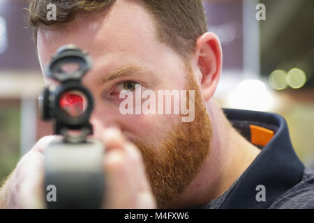 Mann mit einer Pistole Sicht oder Spotter schauen in die Kamera Stockfoto