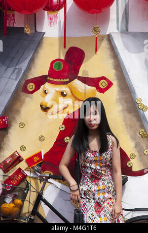 Kuala Lumpur, Kuala Lumpur, Malaysia. 16 Feb, 2018. Eine Dame vor ein großes Poster mit dem Hund Jahr am Thean Hou Tempel am ersten Tag des chinesischen neuen Jahres gesehen. Das chinesische Neujahr ist der erste Tag des neuen Jahres nach dem chinesischen Kalender, der von den Gregorianischen Kalender unterscheidet. Es ist auch, wie das Frühlingsfest oder das Neujahrsfest bekannt. Traditionell werden die Feierlichkeiten beginnen am Abend vor dem ersten Tag der 15. Tag des ersten Monats. Zum 15. Tag ist auch als Laternenfest. Tag, vom 16. Februar Credit: ZUMA Press, Inc./Alamy leben Nachrichten Stockfoto