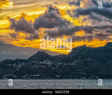 Giardini Naxos, Sizilien, Italien. 12. Okt. 2004. Eine brillante Sonnenuntergang Verschütten von Flüssigkeiten durch die dramatische Wolken über dem Badeort Giardini Naxos, Sizilien, auf das Ionische Meer. Sizilien hat sich zu einem beliebten Reiseziel geworden. Credit: Arnold Drapkin/ZUMA Draht/Alamy leben Nachrichten Stockfoto