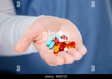 Nahaufnahme der männlichen Hand Haufen Pillen Stockfoto