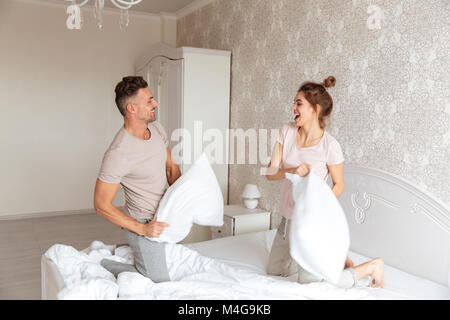 Bild von fröhlichen Paar schöne Spaß zusammen auf dem Bett zu Hause. Stockfoto