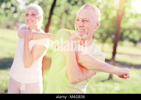 Ältere Familie stretching Arms im Freien Stockfoto