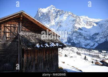 Holz Stall im Winter und Wetterhorn im Hintergrund, Grindelwald, Schweiz Stockfoto