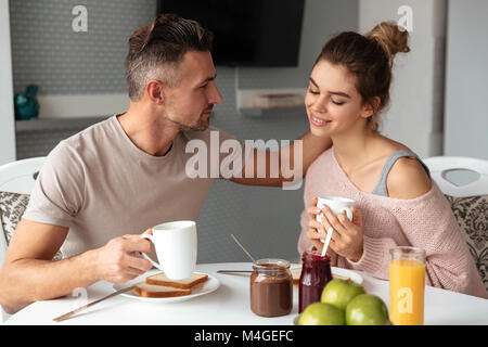 Portrait einer jungen Liebespaar, das Frühstück am Tisch in einer Küche zu Hause sitzen Stockfoto