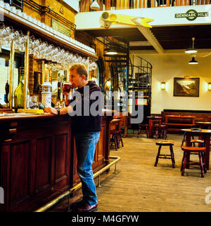 Kunden, trinken ein Glas Bier in der Bar in der Phoenix und Firkin Pub, alte Ticket Halle von Dänemark Hill Bahnhof, brannte im Jahre 1980 dann wurde renoviert und als ein öffentliches Haus, 1987 fotografiert geöffnet Stockfoto