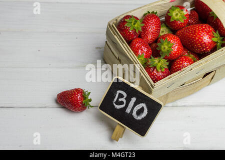 Punnet voller Frische reife Erdbeeren auf weißem Hintergrund Holz Stockfoto