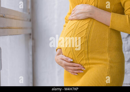 Schwangerschaft, Mutterschaft, Erwartung Konzept - Nahaufnahme der Glückliche schwangere Frau mit großen Bauch im Fenster Stockfoto