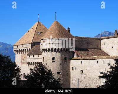 Blick auf die steinernen Mauern und Türmen der mittelalterlichen Schloss Chillon schloss in der Schweiz im alpinen Genfer See in Montreux Stadt, Kanton Waadt, klare blaue Stockfoto