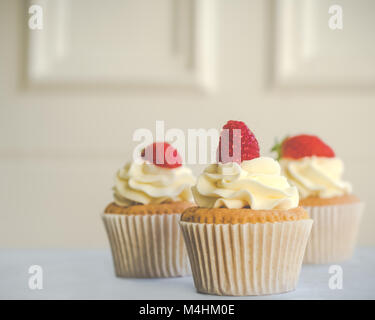 Drei Berry und Cream Cupcakes mit Vanilla Buttercream Frosting Stockfoto