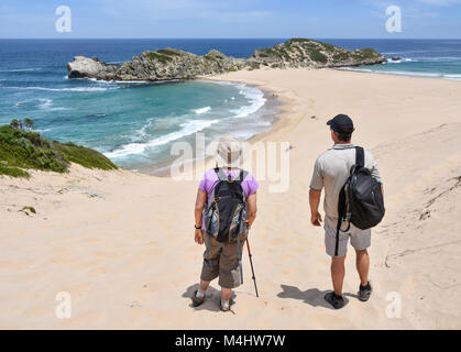 Zwei Wanderer stehen auf dem Strand des Robberg in der Nähe von Plettenberg Bay in Südafrika mit den Strand und den Indischen Ozean im Hintergrund Stockfoto