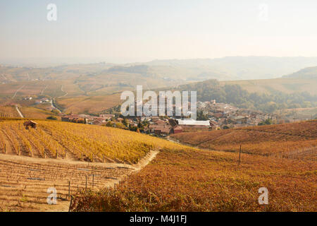 Barolo Stadt durch Weinberge im Herbst mit gelben Blätter an einem sonnigen Tag in Piemont, Italien umgeben Stockfoto