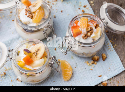 Gesundes Frühstück Übernachtung Hafer mit frischem Obst im Glas auf Holz- Hintergrund Stockfoto