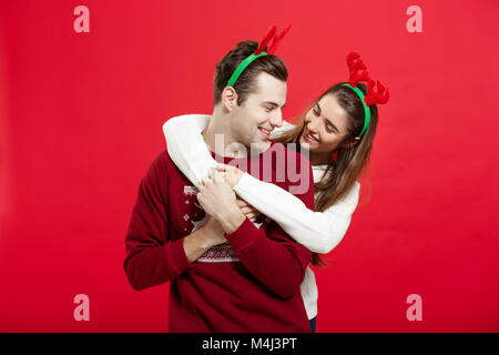 Weihnachten Konzept - Romantisches Paar in einem Weihnachten Pullover huging einander Stockfoto