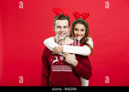 Weihnachten Konzept - Romantisches Paar in einem Weihnachten Pullover huging einander Stockfoto