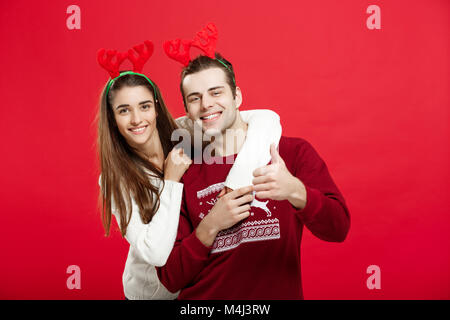 Weihnachten Konzept - Romantisches Paar in einem Weihnachten Pullover huging einander Stockfoto