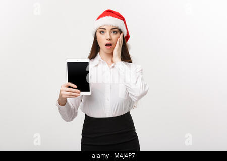 Geschäftskonzept - Junge kaukasier Business woman in Weihnachten Thema anzeigen digital Tablet mit überraschenden Gesichtsausdruck. Stockfoto